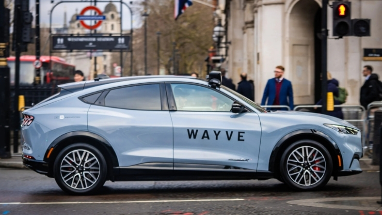 Wayve-branded vehicle on city street with traffic lights