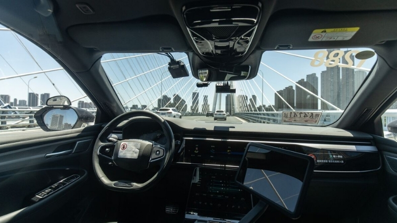 Wind turbines and power lines across open landscape with mountains
